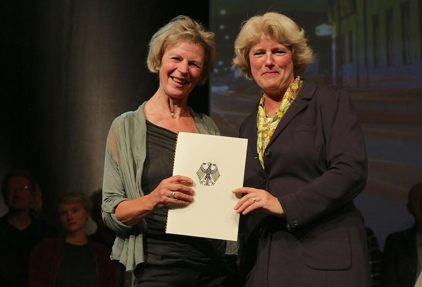 Ingrid Wolschin nimmt die Auszeichnung "Applaus" für den Karlstorbahnhof aus der Hand von Kulturstaatsministerin Monika Grütters entgegen.